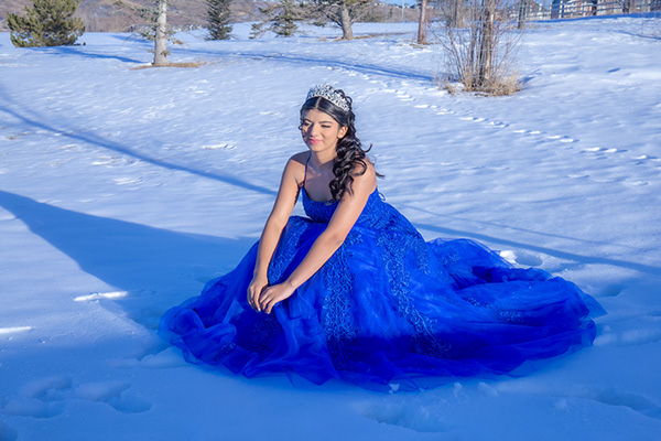 Photographie d’une quinceañera en robe bleue dans la neige au Québec